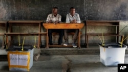 Election observers sit in an empty polling station for the presidential elections in Bujumbura, Burundi, July 21, 2015. 