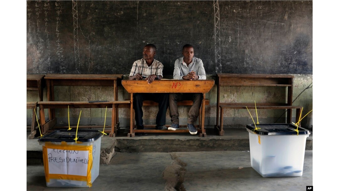 Election observers sit in an empty polling station for the presidential elections in Bujumbura, Burundi, July 21, 2015.