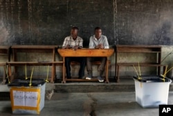 Election observers sit in an empty polling station for the presidential elections in Bujumbura, Burundi, July 21, 2015.