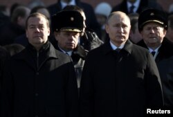 FILE - Russian President Vladimir Putin and Prime Minister Dmitry Medvedev attend a wreath laying ceremony to mark the Defender of the Fatherland Day at the Tomb of the Unknown Soldier by the Kremlin wall in central Moscow, Russia, Feb. 23, 2018.