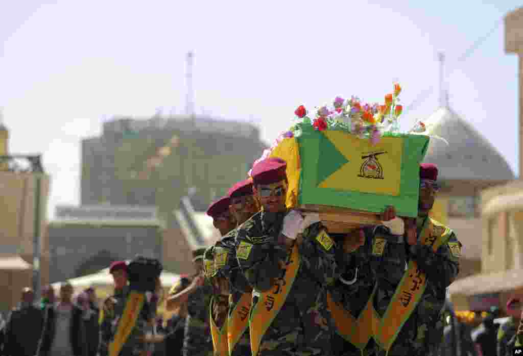 Iraqi Hezbollah fighters carry the coffin of their comrade, Ali Mansour, who his family says was killed in Tikrit fighting Islamic militants, during his funeral procession, in the Shiite holy city of Najaf, Iraq, March 2, 2015. 