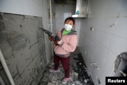 Deng Qiyan, 47, a mother of three and a decoration worker at contraction sites, poses for a photograph at an apartment building under construction in Beijing, China, Feb. 22, 2017.