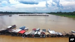 FILE - Dredging barges operated by illegal miners converge on the Madeira river, a tributary of the Amazon River, searching for gold, in Autazes, Amazonas state, Brazil, Nov. 25, 2021.