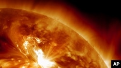 This handout image provided by NASA, taken Sunday night, Jan. 22, 2012, shows a solar flare erupting on the Sun's northeastern hemisphere. 