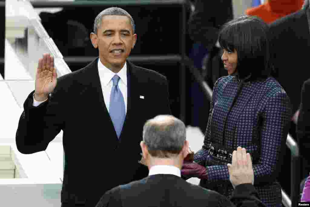 Tổng thống Obama đọc lời thề trước thẩm ph&aacute;n Chủ tịch T&ograve;a &Aacute;n Tối Cao John Roberts, b&ecirc;n cạnh l&agrave; Đệ nhất Phu nh&acirc;n Michelle Obama n&acirc;ng quyển Th&aacute;nh Kinh. (Reuters)