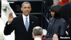 U.S. President Barack Obama is sworn in by Supreme Court Chief of Justice John Roberts, as first lady Michelle Obama looks on during inauguration ceremonies in Washington, D.E., January 21, 2013. 