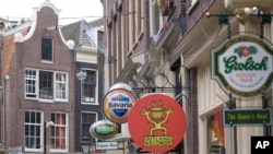 FILE - Advertisements for beer brewers Heineken (far l) Brand, owned by Heineken, Bavaria, (c) and Grolsch (far r), are seen in the center of Amsterdam, Netherlands, Oct. 1, 2007. 