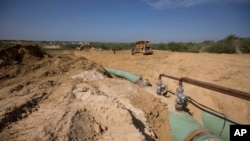 FILE - In this Sept. 7, 2014 photo, new pipelines to carry gas from Texas to Mexico, eventually reaching the city of Guanajuato, are laid underground near General Bravo, in Nuevo Leon state, Mexico. 