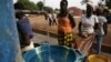 Girls fill plastic basins at a free water tap in a neighborhood where houses with indoor plumbing rarely receive water, in Bissau, Guinea-Bissau, March 6, 2009. Contaminated drinking water leads to yearly cholera epidemics, particularly in remote rural re