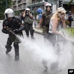 A policeman sprays tear gas as a protester walks away during an anti-austerity rally in Athens June 29, 2011.
