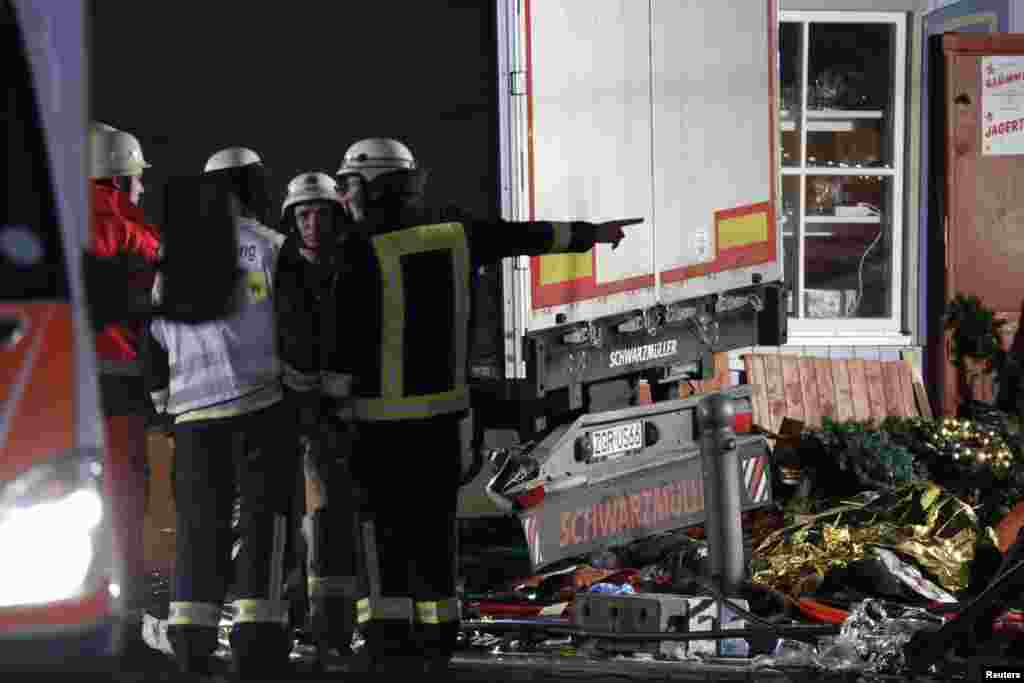 Seorang petugas pemadam kebakaran berdiri di sebelah truk di pasar Natal di bagian barat Berlin, Jerman (19/12). (Reuters/Pawel Kopczynski)