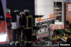 Firefighter stand beside a truck at a Christmas market in Berlin, Dec 19, 2016 after the truck ploughed into the crowded Christmas market in the German capital.