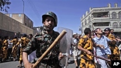 Yemeni riot police charge towards anti-government protesters, during a demonstration demanding the resignation of President Ali Abdullah Saleh, in Sana'a, February 18, 2011