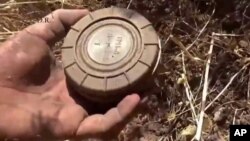  A volunteer deminer takes a landmine from the ground in Daraa, Syria. (File)