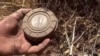 FILE - In this still image made from video taken Sept. 7, 2015, provided by the Syrian Center for Demining and Rehabilitation, a volunteer deminer takes a land mine from the ground in Daraa, Syria.