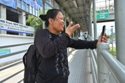 Penyandang tunarungu saling berkomunikasi menggunakan bahasa isyarat melalui televideo. (Foto: AFP)