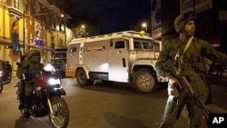 Soldiers stand guard as one of the first armored trucks containing gold reserves arrives at the Central Bank in Caracas, Venezuela, November 25, 2011.