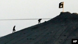 Kobani'de bir tepeye bayrak diken IŞİD militanları