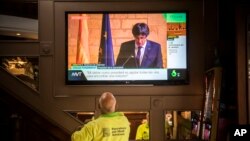 Gente en un bar en Barcelona, España, mira en televisión el discurso del presidente regional catalán Carles Puigdemont, el jueves, 26 de octubre de 2017.
