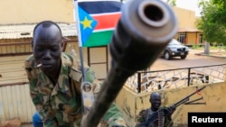 A South Sudan army soldier stands next to a machine gun mounted on a truck in Malakal, capital of Upper Nile state, which an official says is controlled by forces loyal to former Vice President Riek Machar. 