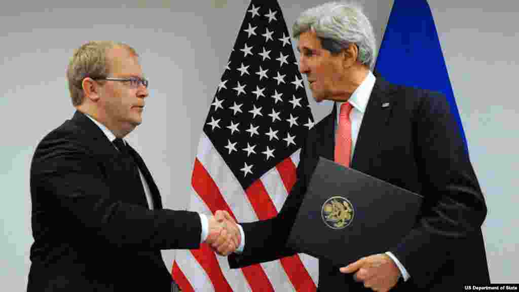 U.S. Secretary of State John Kerry shakes hands with Estonian Foreign Minister Urmas Paet after signing the U.S.-Estonia Cyber Partnership Statement on the margins of a NATO Ministerial meeting in Brussels, Belgium, on December 3, 2013. 