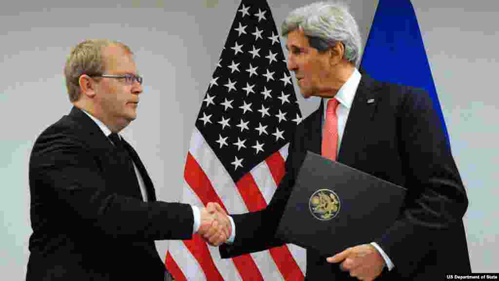 U.S. Secretary of State John Kerry shakes hands with Estonian Foreign Minister Urmas Paet after signing the U.S.-Estonia Cyber Partnership Statement on the margins of a NATO Ministerial meeting in Brussels, Belgium, on December 3, 2013.