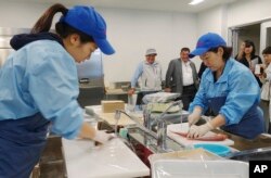 Lab technicians at the Fukushima Prefectural Fisheries Experimental Station at Onahama Port in Iwaki city prepare fish to measure cesium levels for safety tests under the prefecture's experimental fishing program, Oct. 12, 2017.