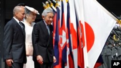 Cambodian King Norodom Sihamoni, left, follows Japanese Emperor Akihito, right, and Empress Michiko, center, on their way to a welcoming ceremony at the Imperial Palace, in Tokyo, Japan, Monday, May 17, 2010. 