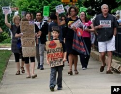 Jackson Borrello, 8, leads activists outside U.S. Senator Tom Tillis' office at the Federal Building to demand the reunification of families separated at the border in Raleigh, N.C., June 26, 2018.
