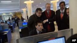 Tổng giám đốc Google Eric Schmidt (giữa), và cựuThống đốc New Mexico Bill Richardson (thứ 2, phải) xem một sinh viên Bắc Triều Tiên sử dụng internet tại phòng thực nghiệm trong khi 2 ông đến thăm Đại học Kim Il Sung ở Bình Nhưỡng, 8/1/13