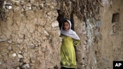 FILE - An Afghan refugee girl outside her home in slums of Islamabad, Pakistan.