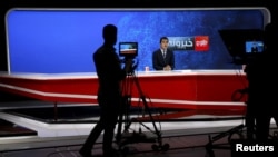 Seorang kameramen merekam pembawa berita dalam menjalankan tugasnya di studio Tolo News di Kabul, Afghanistan, pada 18 Oktober 2015. 