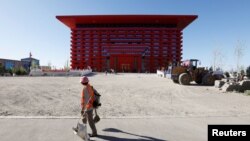 A cleaning worker walks in front of a House of Culture at the Chinese part of the China-Kazakhstan Horgos International Border Cooperation Center (ICBC), in Horgos, China, May 12, 2017. 