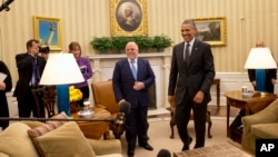 Iraqi Prime Minister Haider Al-Abadi and President Barack Obama get up from their seats after their meeting in the Oval Office of the White House in Washington, April 14, 2015.