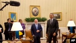 FILE - Iraqi Prime Minister Haider Al-Abadi and President Barack Obama get up from their seats after their meeting in the Oval Office of the White House in Washington, April 14, 2015.