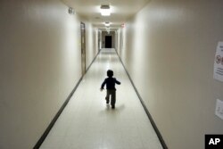 FILE - An asylum-seeking boy from Central America runs down a hallway after arriving from an immigration detention center to a shelter in San Diego, Calif., Dec. 11, 2018.