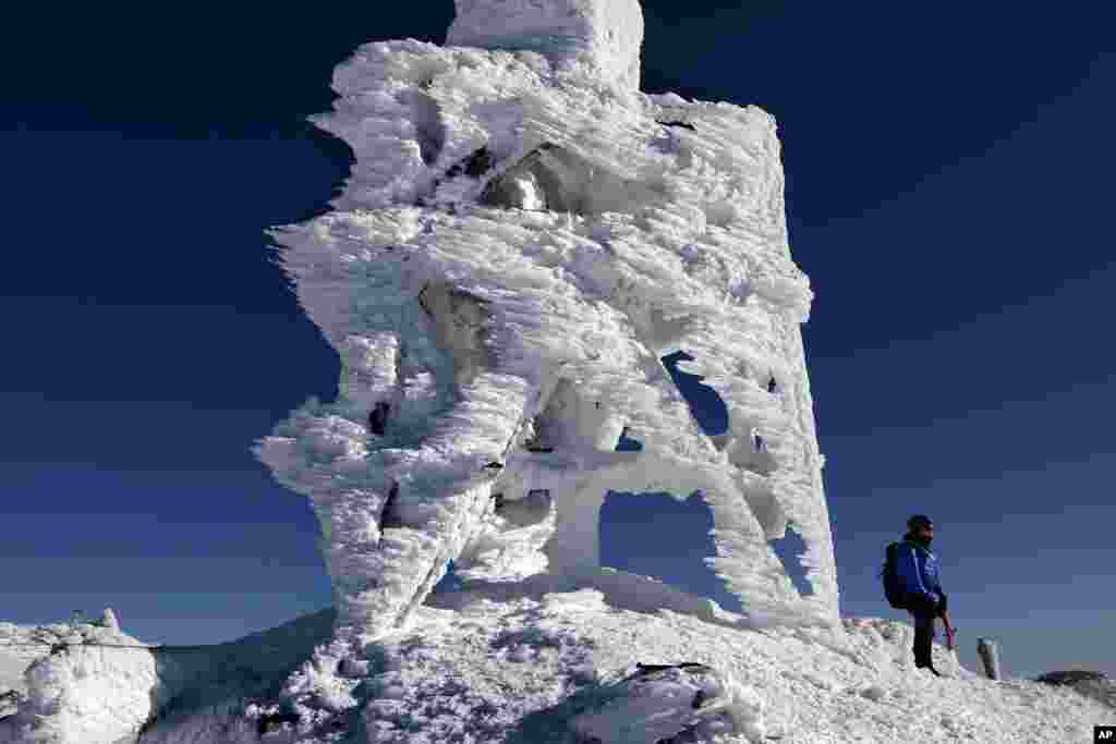 Douglas Ciampi of Westminster, Massachusetts stands next to an ice-covered antenna on top of Mount Washington in the northeastern U.S. state of New Hampshire, Feb. 23, 2020.