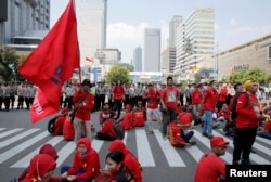 Para pekerja beristirahat di sela pawai Hari Buruh (May Day) di Jakarta, Indonesia, 1 Mei 2018. (Foto: REUTERS/Beawiharta)