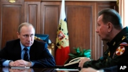 FILE - Russian President Vladimir Putin, left, and Commander-in-Chief of the Interior Ministry troops Viktor Zolotov attend a meeting in the Kremlin in Moscow, Russia, April 5, 2016.