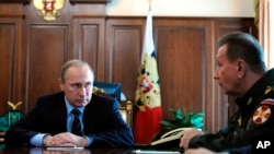 FILE - Russian President Vladimir Putin, left, and Commander-in-Chief of Interior Ministry troops Viktor Zolotov attend a meeting at the Kremlin in Moscow, Russia, April 5, 2016.