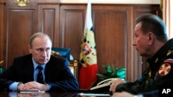 FILE - Russian President Vladimir Putin, left, and General Viktor Zolotov, commander of Interior Ministry troops, confer in the Kremlin in Moscow, April 5, 2016. Zolotov is slated to lead the new National Guard.