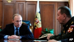 FILE - Russian President Vladimir Putin, left, and Commander-in-Chief of the Interior Ministry troops Viktor Zolotov attend a meeting in the Kremlin in Moscow, Russia, April 5, 2016.