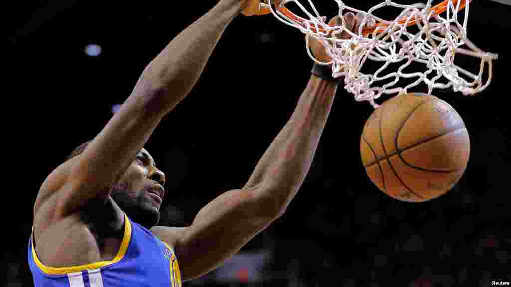 Festus Ezeli: Taurarin Wasan Kwallon Kwando na Najeriya dake NBA Suna Wasa da Kwallo. Golden State Warriors' Festus Ezeli, of Nigeria dunks against the Phoenix Suns during the first half of an NBA basketball game on Friday, April 5, 2013