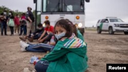 Chanel, un menor no acompañada de siete años,de Honduras, se sienta en medio de otros niños solicitantes de asilo mientras esperan ser transportados a una instalación de procesamiento de la patrulla fronteriza de EE. UU. tras cruzar el Río Grande hacia EE. UU.