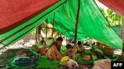 စစ်ကိုင်တိုင်းထဲက တောတွင်း ထွက်ပြေးပုန်းရှောင်နေကြရသူတချို့ (ဓာတ်ပုံ - AFP) 