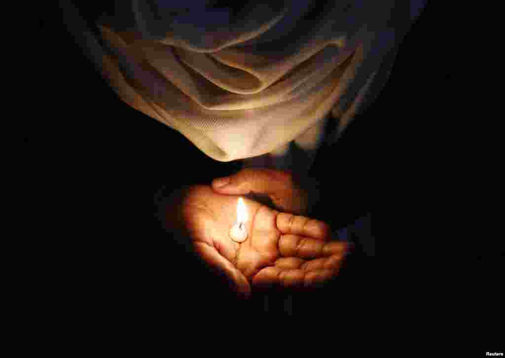 A Christian holds a candle during a vigil to show solidarity with the nun, who was raped during an armed assault on a convent school, in New Delhi, India.