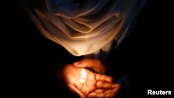 A Christian holds a candle during a vigil to show solidarity with the nun who was raped during an armed assault on a convent school, in New Delhi March 16, 2015. Christians in India said on Monday that the Hindu nationalist government of Prime Minister Na