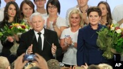 Conservative Law and Justice (PiS) leader Jaroslaw Kaczynski, left, and PiS candidate for prime minister Beata Szydlo, right, react to preliminary election results at the party's headquarters in Warsaw, Poland, Oct. 25, 2015.