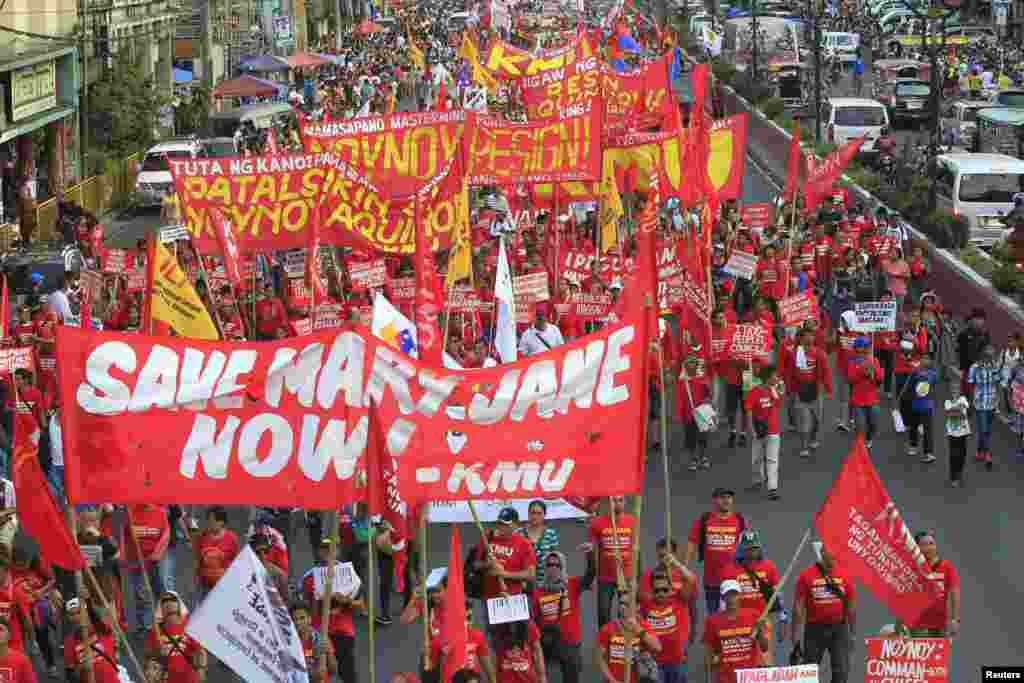 Para pekerja membawa spanduk &quot;Selamatkan Mary Jane Veloso,&quot; seorang pekerja migran Filipina yang divonis bersalah menyelundupkan narjoba, yang akan dieksekusi di Indonesia, beserta dengan berbagai spanduk dengan slogan-slogan anti-pemerintah sembari berbaris menuju istana kepresidenan di Manila.&nbsp;