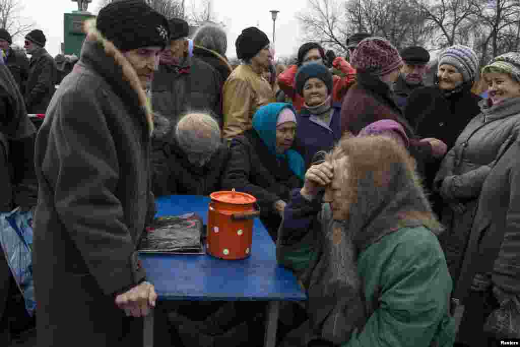 People queue for free food distributed by pro-Russian rebels in the village of Chornukhyne near the town of Debaltseve, March 12, 2015.